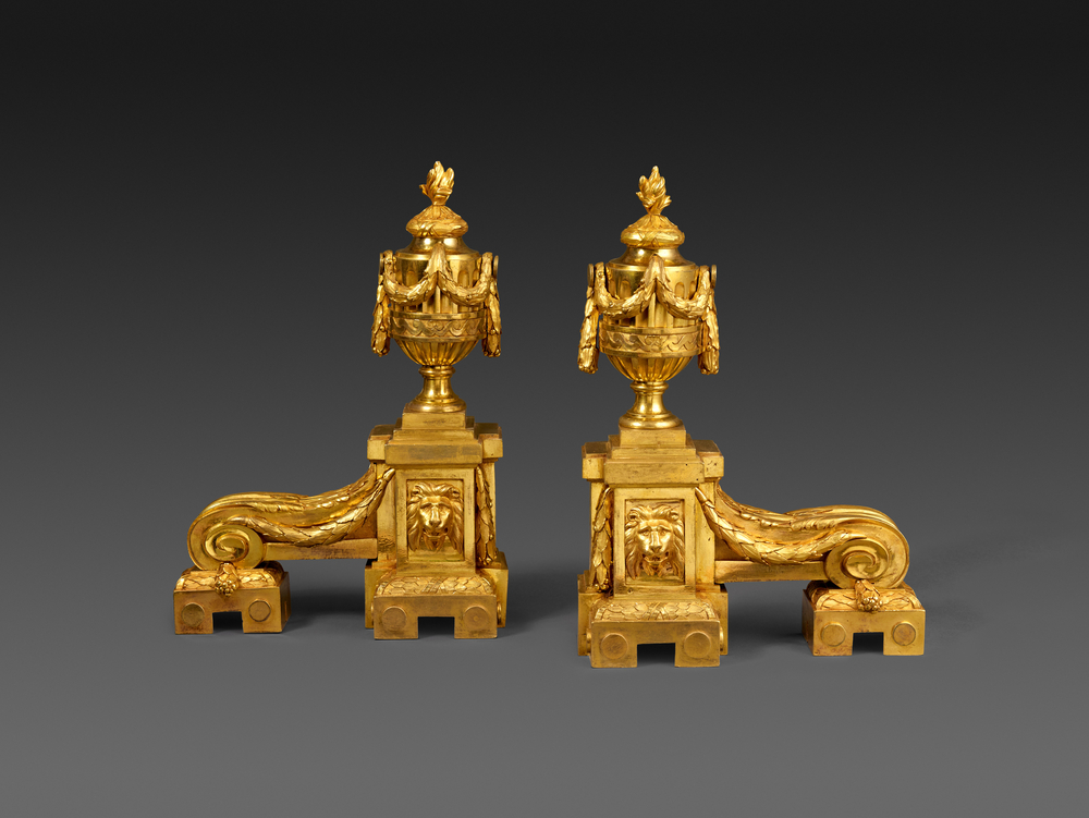 Une paire de chenets dorés en forme de vase