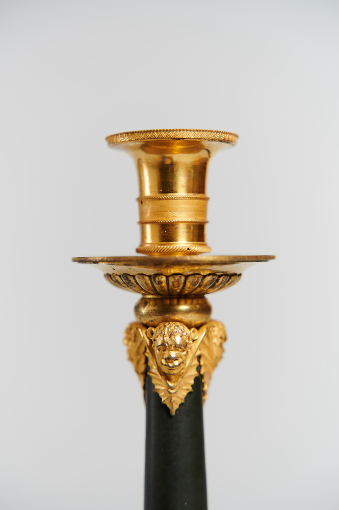 Ein Paar Kerzenhalter aus vergoldeter und patinierter Bronze