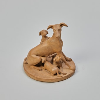 A Sitting Greyhound with her Three Young Puppies